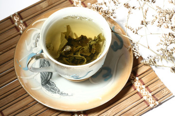 Green tea in a chinese cup with a tea leafs