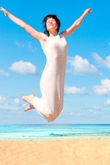 Fototapeta na wymiar Girl jumping happily on a beach