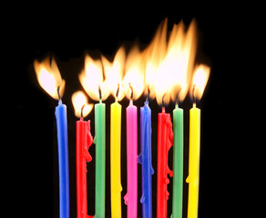 Color candles with flame on black background