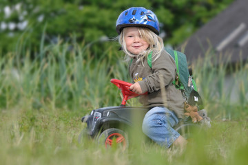 lächelndes Kind auf Bobbycar