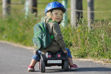 Kind mit Helm auf Bobbycar