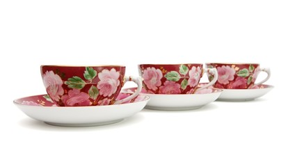 Three tea cups with saucers painted with floral pattern isolated