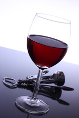 Einzelnes Glas Rotwein schräg mit Korkenzieher
