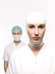 Woman prepared for plastic surgery with a nurse at her back