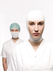 Woman prepared for plastic surgery with a nurse at her back
