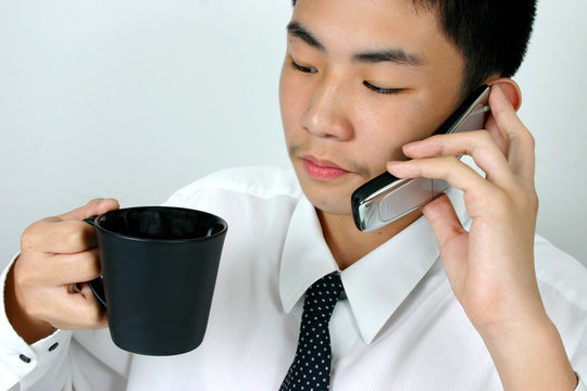 Young businessman having coffee and talking in the same time.