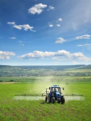 Foto op Plexiglas Landbouwtractor ploegen en spuiten op veld verticaal © ValentinValkov