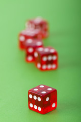 Red dice against green background - shallow DOF