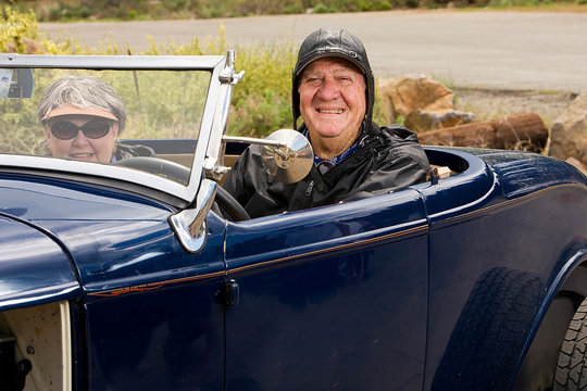 Happy Elderly Retired Couple In Classic Car