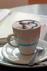 morning cup of cappuchino with fresh magazine