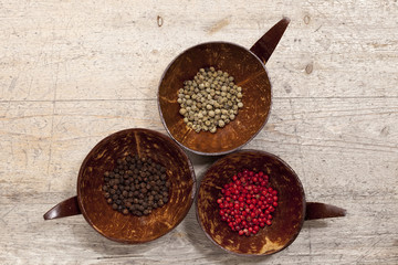 three tipe of peppercorns from above, old wooden background