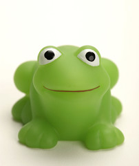 green plastic frog on white background smiling
