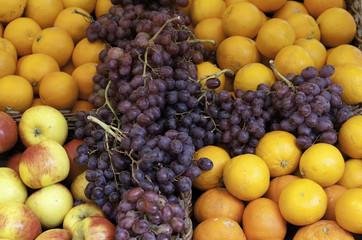 Naklejka na ściany i meble Oranges, grapes and apples at a market stand
