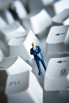 Business figurine placed with computer keys