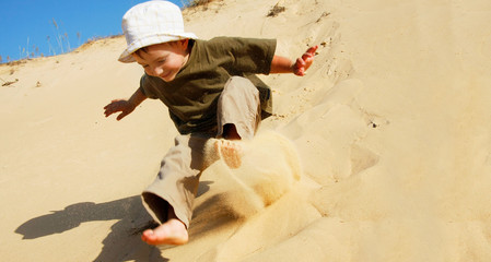 young boy jumping in sands