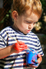 young boy ready to paint outdoors portrait