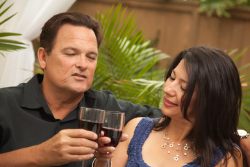 Attractive Hispanic and Caucasian Couple Drinking Wine