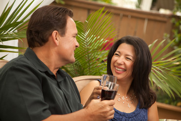 Attractive Hispanic and Caucasian Couple Drinking Wine