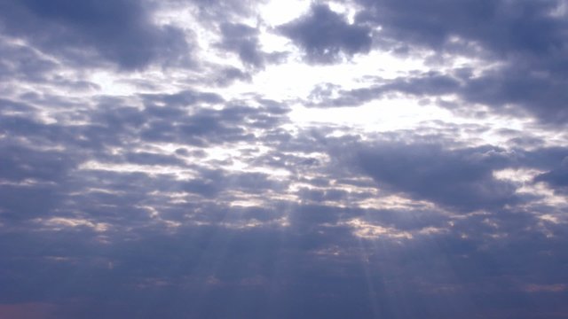 Time lapse clip with sunrays through the clouds