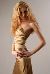 Fototapeta premium Caucazian model in gold sexy dress