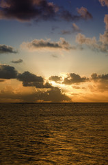 Naklejka na ściany i meble Sunset behind dark Clouds over Sea
