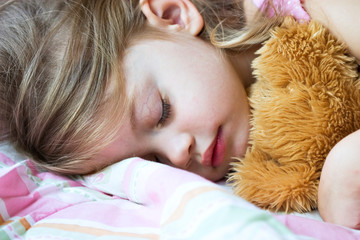 Toddler sleeping with her teddy bear