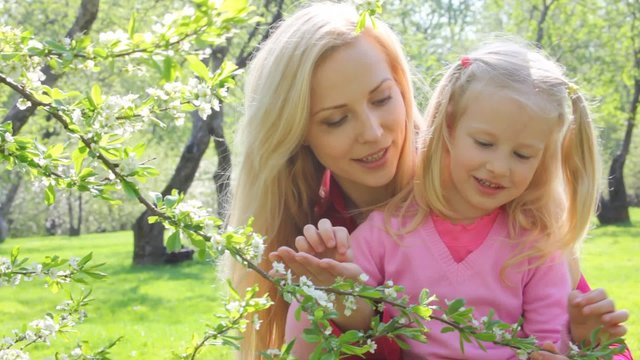 girl plays with branch of the aple trees