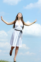 beautiful girl in a white dress on a background of the blue sky