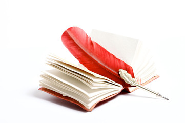 a red writing feather on a diary on a white background