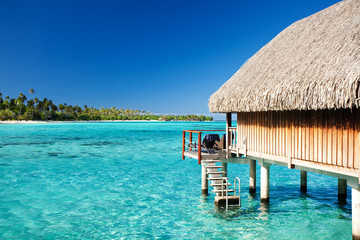 Over water bungalow with steps into lagoon - obrazy, fototapety, plakaty