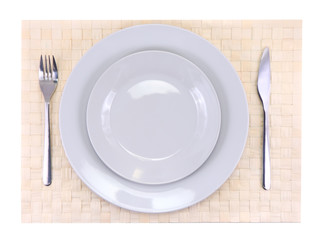 Table appointments(arrangement) of flatware on bamboo mat.