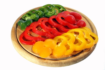 Red yellow orange green pepper on a chopping board