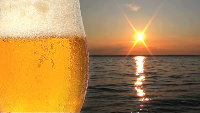 k&uuml;hles frisches bier mit sonnenuntergang