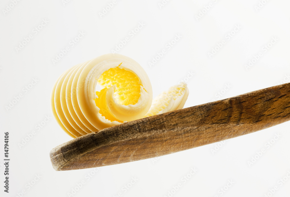 Wall mural Butter curl on a wooden spoon