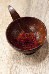 saffron spice oncoconut bowl on old wooden table