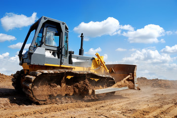 bulldozer with raised blade in action - obrazy, fototapety, plakaty