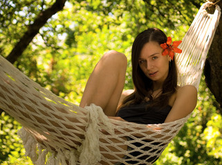 Beautiful young woman lying in hammock