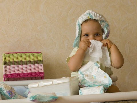 B&eacute;b&eacute; jouant avec des couches sur une table &agrave; langer