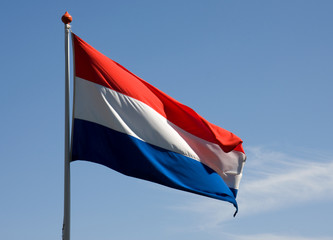 Fluttering Dutch flag over blue sky