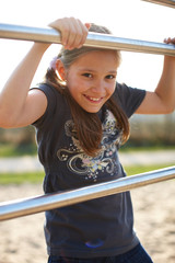Fototapeta premium Mädchen am Reck auf Spielplatz