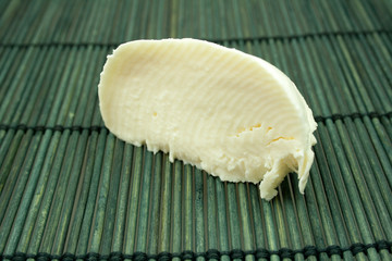 Ein halbes Stück Mozarella auf Bambusmatte