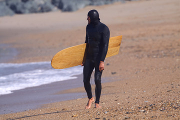 homme avec sa planche de surf sur la plage