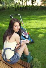 garden work, woman mowing grass with lawnmower