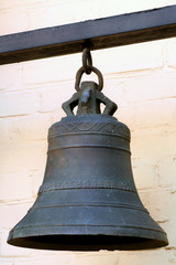 Fototapeta premium Solid Iron Bell on the Background of Wall