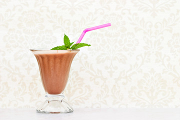 Chocolate milkshake with mint and straw