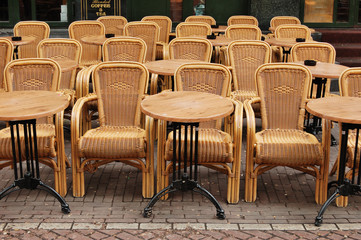Fototapeta na wymiar Puste stoły i krzesła z rattanu wikliny w kawiarni ulicznej