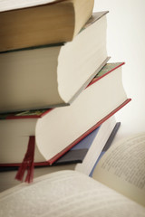stack of books with an open book in foreground