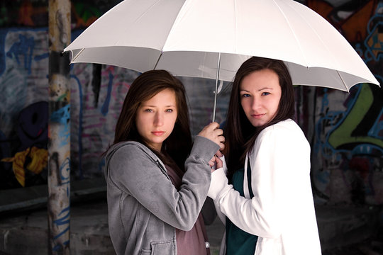 Teeangers Holding an Umbrella
