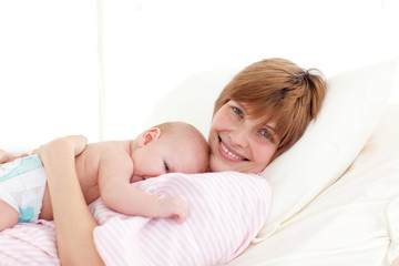 Fototapeta na wymiar Mother with newborn baby in bed smiling at the camera