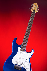 Blue Guitar Isolated Against Red